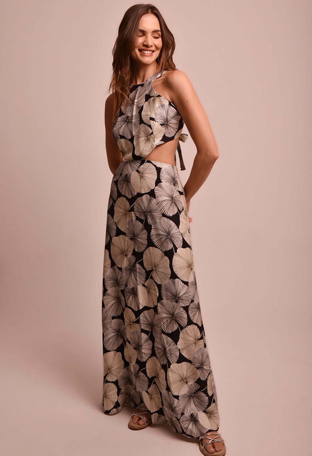 Vestido longo Martina Sublime com estampa floral, recortes laterais e amarração nas costas, modelo sorrindo