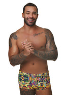 Modelo masculino vestindo sunga short adulto estampado Tropicalia multicolorido em fundo branco