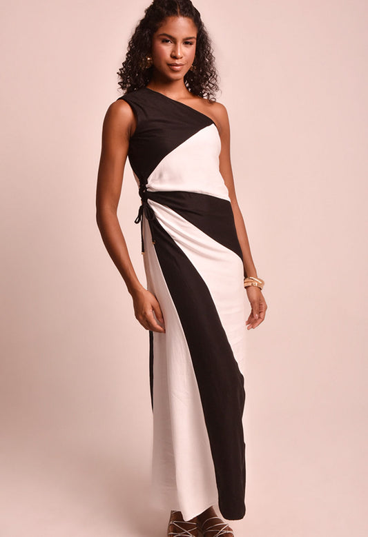 Vestido longo bicolor preto e branco com um ombro só, laço lateral e design assimétrico, modelo feminino.