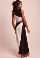 Vestido longo bicolor preto e branco, vista traseira, com amarração lateral e design assimétrico.