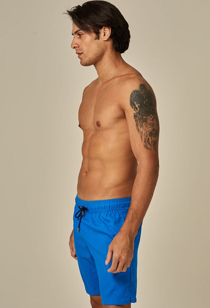 Bermuda casual de linho azul para homem vista de perfil, com elástico e cordão na cintura.