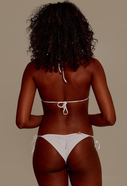 Mulher negra de costas usando biquíni branco com calcinha levanta bumbum, vista traseira.