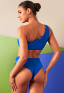 Calcinha Hot Dupla Argola Refresco azul royal com argolas douradas, vista traseira com modelo feminina