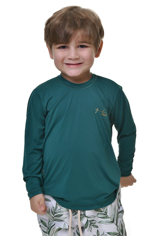 Camiseta de proteção UV infantil verde petróleo manga longa com logo dourado, usada por menino em fundo branco