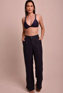 Calça pantalona marinho com cintura alta e bolsos laterais, usada com top de biquíni azul marinho, modelo frontal.