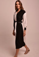 Vestido chemise bicolor preto e branco, vista lateral com faixa amarrada na cintura.