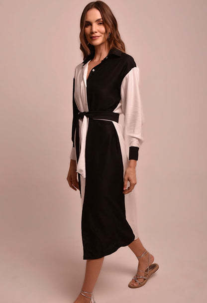 Vestido chemise bicolor preto e branco, vista lateral com faixa amarrada na cintura.