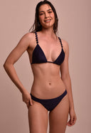 Mulher usando biquíni azul marinho Calcinha Cris Marinho com fundo bege